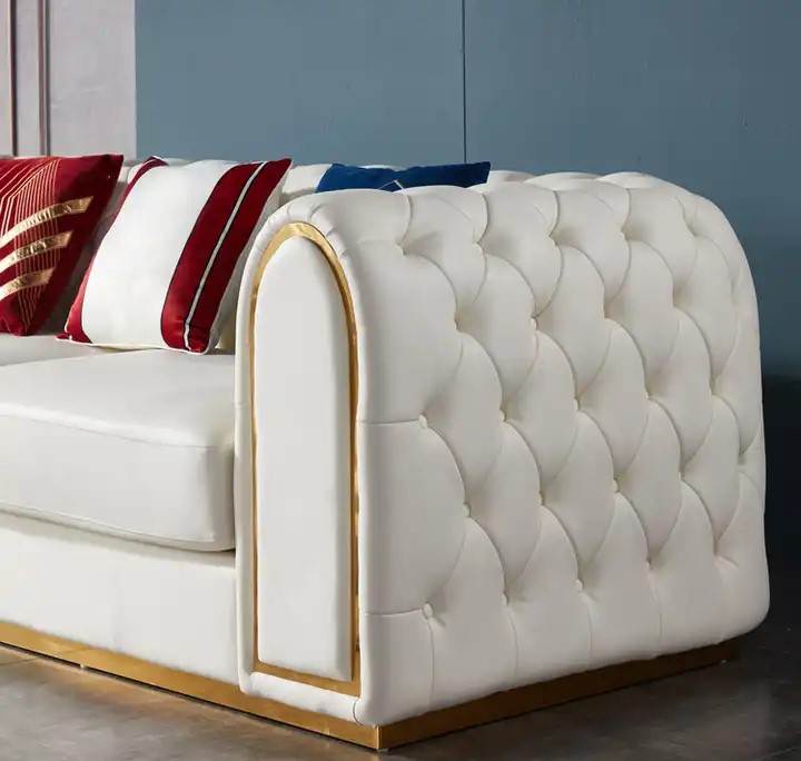 biała sofa ze złotymi dodatkami