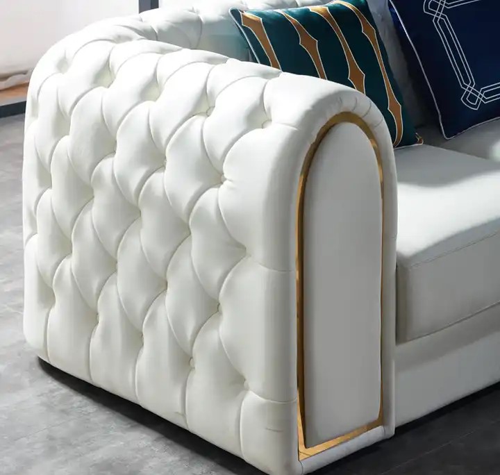 biała sofa ze złotymi dodatkami