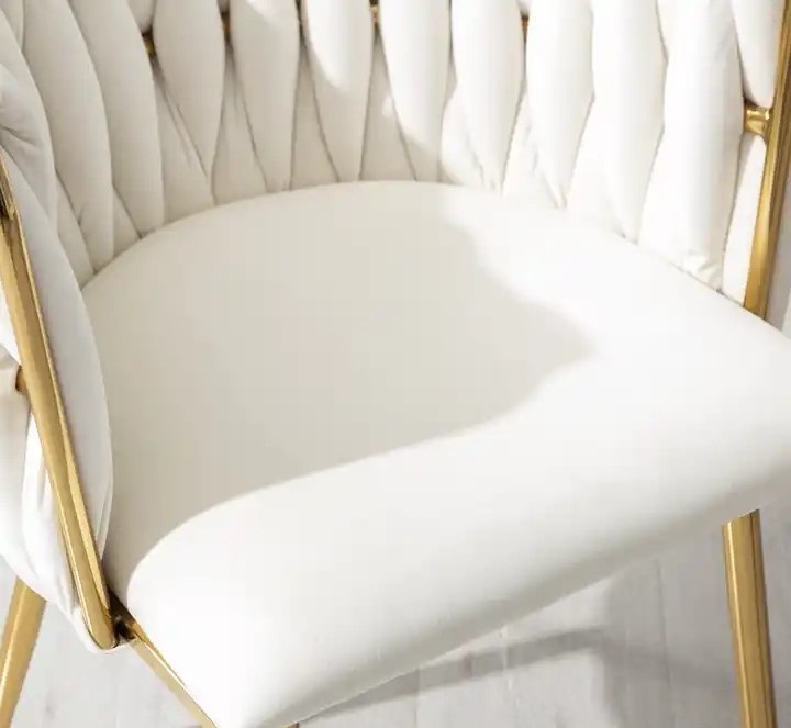 welurowe białe krzesło na złotym stelażu